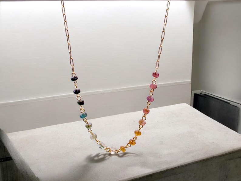 Gorgeous rainbow tourmaline rondelle beaded necklace that is wire wrapped toa 14k gold filled paperclip chain.  Handmade and handcrafted natural gems