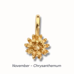 Gold birth flower charm representing each month, featuring a delicate embossed floral design on a round gold pendant — a personalized jewelry gift for her.