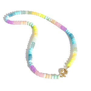 May include: A colorful beaded necklace with a gold clasp. The beads are in shades of blue, green, yellow, pink, and purple.