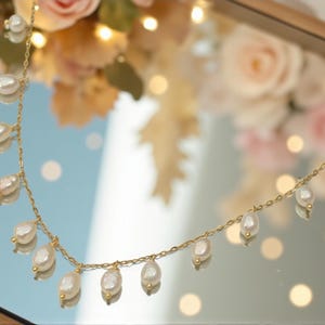 Delicate freshwater pearl necklace with gold chain and dangling pearl drops styled gemininr mirror.