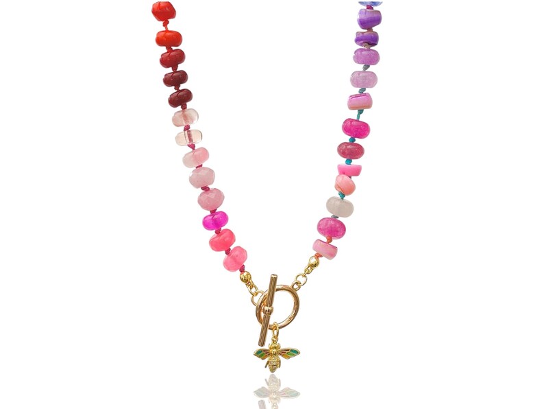 A rainbow multi-gemstone opal necklace that is hand-knotted & handcrafted.  Made from natural semi precious opal gemstones.  This necklace is sure to add a pop of color to any outfit. It features a gold dragonfly pendant.