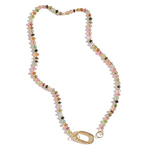 May include: A multi-colored gemstone necklace with a gold clasp. The necklace is made of small, round beads in various shades of pink, green, blue, and black.