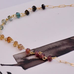 Gorgeous rainbow tourmaline rondelle beaded necklace that is wire wrapped toa 14k gold filled paperclip chain.  Handmade and handcrafted natural gems