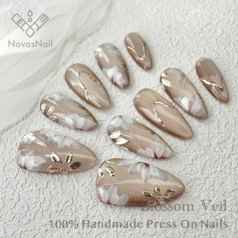 Neutral shimmer nails featuring cat eye gel and floral patterns.