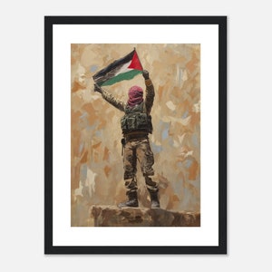 Può includere: Un dipinto di una persona che indossa un keffiyeh rosso e abiti mimetici, che tiene in alto una bandiera palestinese. La persona è in piedi su uno sperone roccioso su uno sfondo marrone e beige.