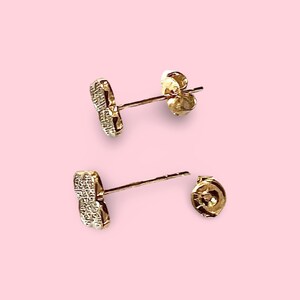 Puede incluir: Un par de pendientes de tono dorado con un peque&ntilde;o dise&ntilde;o de coraz&oacute;n de cristal transparente. Los pendientes tienen un cierre de poste.