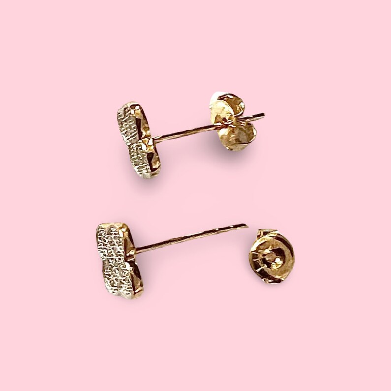 Puede incluir: Un par de pendientes de tono dorado con un peque&ntilde;o dise&ntilde;o de coraz&oacute;n de cristal transparente. Los pendientes tienen un cierre de poste.