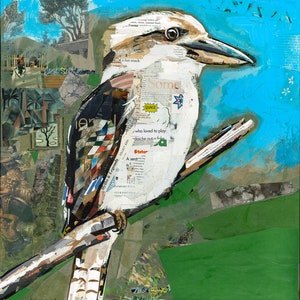 May include: A collage artwork featuring a kookaburra bird perched on a branch. The bird is made of paper scraps and has a white body with brown and black markings. The background is a bright blue sky with green foliage.