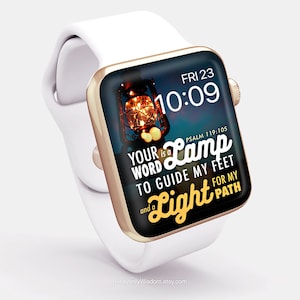 Puede incluir: Un Apple Watch blanco con una banda dorada muestra una esfera de reloj digital con la hora 10:09 y la fecha VIE 23. La esfera del reloj también presenta una cita del Salmo 119:105, "Tu palabra es una lámpara para guiar mis pies y una luz para mi camino." La cita se muestra en una fuente dorada con una imagen de linterna vintage en el fondo.