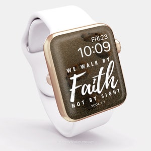 Op de afbeelding: Een witte Apple Watch met een roségouden band en een bruine achtergrond met de tekst "WE WALK BY FAITH NOT BY SIGHT 2COR 5:7".
