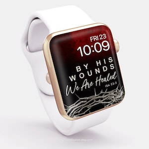 Op de afbeelding: Een witte Apple Watch met een gouden band en een rood en zwart wijzerplaat. De wijzerplaat toont de tijd "FRI 23 10:09" en de tekst "BY HIS WOUNDS WE ARE HEALED ISA 53:5". Een doornenkroon is zichtbaar op de wijzerplaat.