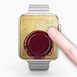 Op de afbeelding: Een zilveren Apple Watch met een vintage-wijzerplaat. De wijzerplaat heeft een rode waszegel met het woord "Faith" in cursief. De tijd is 10:09 en de datum is FRI 23.
