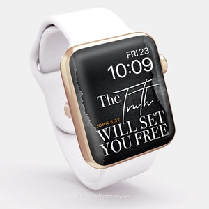 May include: A white Apple Watch with a black face and gold trim. The face displays the time, "FRI 23 10:09", and the text "The Truth Will Set You Free" with the scripture reference "JOHN 8:32".