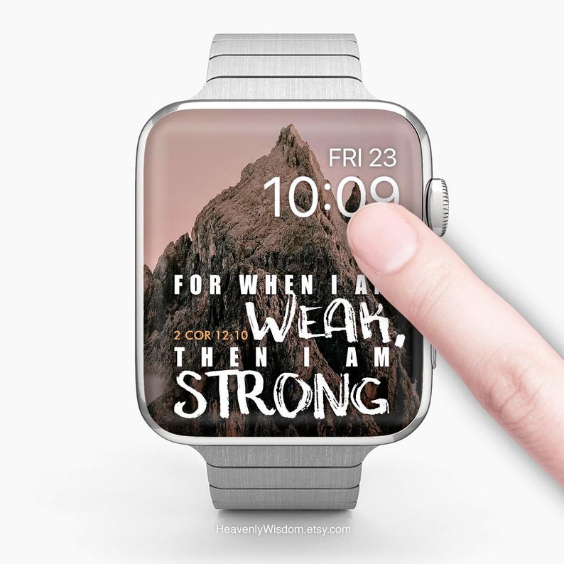 May include: A silver smartwatch with a mountain landscape on the screen. The screen displays the time, date, and the text "For when I am weak, then I am strong." A finger is touching the screen. The website address "HeavenlyWisdom.etsy.com" is at the bottom.