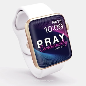 Op de afbeelding: Een witte Apple Watch met een gouden band en een zwart display. Het display toont de tijd, "FRI 23", "10:09", en de tekst "PRAY Continually 1 THES 5:17".
