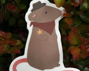 May include: A brown sticker featuring a cartoon rat dressed as a sheriff. The rat wears a brown hat, a burgundy bandana, and a gold star badge. The sticker has a white border and a pink tail, set against a backdrop of green and red leaves.