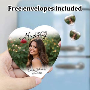 K&ouml;nnte beinhalten: Wei&szlig;es herzf&ouml;rmiges Denkmal mit einem Foto einer Frau mit langen braunen Haaren. Der Text "In Loving Memory" ist in schwarzer Kursivschrift geschrieben. Der Text "Olivia Johnson 1994-2025" ist in schwarzer Schrift geschrieben.