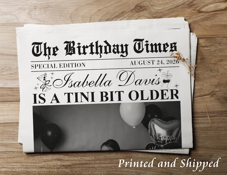 May include: A stack of newspapers with the headline "The Birthday Times" and the date August 24, 2026. The text reads "Isabella Davis IS A TINI BIT OLDER". The image below the text shows balloons.