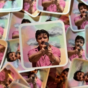 May include: Square stickers depicting a man in a pink shirt aiming a gun, set against a pastel sky. The stickers are scattered, with multiple images of the same design visible.