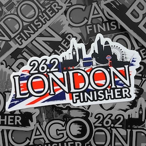 Peut inclure: Un autocollant blanc avec un design de drapeau Union Jack rouge, blanc et bleu. L'autocollant indique "26.2 LONDON FINISHER" en texte noir. L'autocollant présente également une silhouette noire de l'horizon de Londres avec Big Ben et le London Eye.