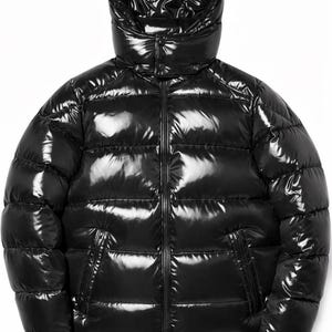 May include: A glossy black puffer jacket with a high collar and attached hood. The jacket features a full-length zipper, side pockets, and a quilted design. The shiny material reflects light, creating a sleek, modern look.