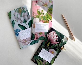 May include: Three floral patterned notebooks with different titles: "Notes", "Weekly Planner", and "Monthly Planner". Each notebook has a white label with the text "Aesthetic & Functional" and "Botanical" printed on it.