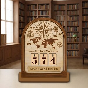 Może przedstawiać: Drewniany dziennik podróży z różą wiatrów, mapą świata i napisem "Explore More". Dziennik wyświetla liczby 574. Tekst "Ethan's World Trek Log" znajduje się na dole. Tłem jest biblioteka.