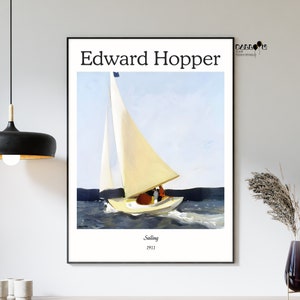 Op de afbeelding: Een vintage poster met een schilderij van Edward Hopper met de titel "Sailing" uit 1911. Het schilderij toont een zeilboot met een wit zeil op een blauwe watermassa onder een lichtblauwe lucht.