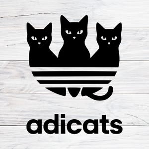 May include: Black graphic featuring three stylized black cats above a striped design, with the word "adicats" below. The design is set against a white wood grain background.