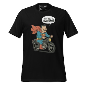 スーパーマンがバイクに乗っている漫画Tシャツ、空を飛ぶのは過大評価されている面白いスーパーヒーローバイカーTシャツ、ライダーへのギフト