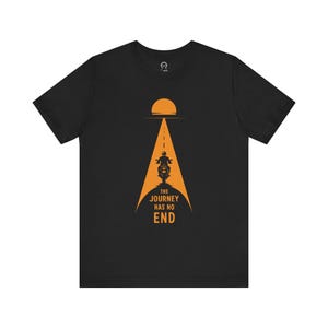 Könnte beinhalten: Schwarzes T-Shirt mit einer orangefarbenen Grafik eines Motorrads, das eine Straße entlangfährt, mit der Sonne darüber. Der Text "The Journey Has No End" befindet sich unter dem Motorrad.