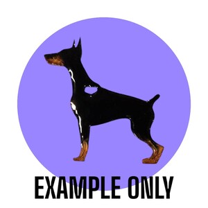 May include: A black Doberman Pinscher dog silhouette with brown detailing, set against a light purple circle. The words "EXAMPLE ONLY" are printed in black below the dog image. The dog has a heart-shaped cutout.