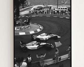 May include: Black and white framed print of a Formula 1 race. Two race cars are cornering on a track, with spectators and flags visible. The image has a vintage aesthetic, with the "Marlboro" logo visible.