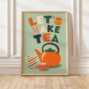 Puede incluir: Una lámina artística enmarcada con fondo verde claro y el texto LET'S MAKE TEA en naranja, verde oscuro y crema. Debajo del texto hay una tetera naranja grande, una taza alta con rayas diagonales rojas y verdes, y una taza pequeña de color rojo.