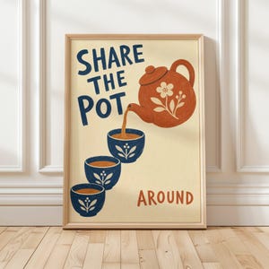 May include: A framed wall art print on a cream background featuring a terracotta-colored teapot pouring tea into three stacked blue cups. The text reads SHARE THE POT in dark blue and AROUND in terracotta, with floral motifs on the teapot and cups.