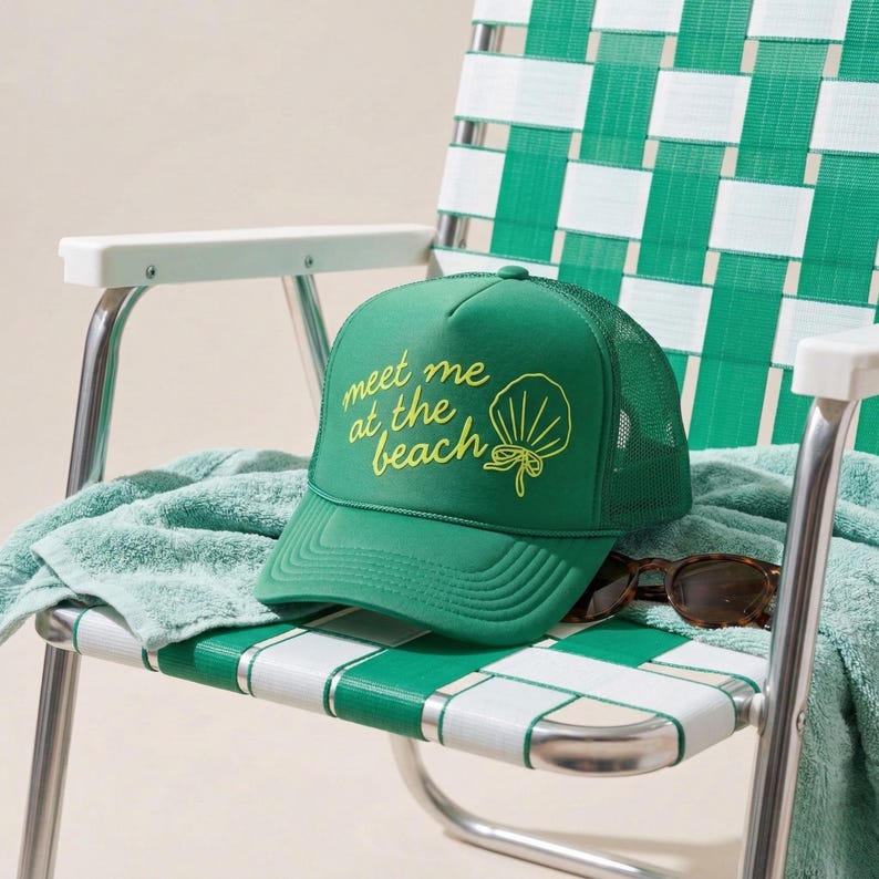 Green beach trucker hat with shell and bow puff vinyl design sitting in retro lawn chair perfect for beach trips summer style and casual outdoor wear