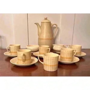 May include: A vintage tea set with a cream and orange checkered pattern. The set includes a teapot, creamer, sugar bowl, and six cups and saucers.