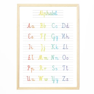 Może przedstawiać: Oprawiony wydruk alfabetu w tęczowym gradiencie, z każdą literą napisaną kursywą na papierze w linie. Słowo "Alphabet" jest napisane w tęczowym gradiencie u góry. Rama jest wykonana z jasnego drewna.