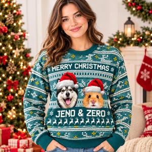 May include: A teal long-sleeve crewneck jumper featuring a white Nordic-style pattern, the text MERRY CHRISTMAS and JENO & ZERO, and a graphic of a husky and a hamster, both wearing red and white Santa hats, centred on the front of the garment.