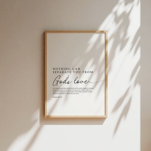 Op de afbeelding: Een printbaar wanddecor met een witte achtergrond en zwarte tekst. De tekst luidt "Niets kan je scheiden van Gods liefde." De tekst gaat verder met een Bijbelvers uit Romeinen 8:38-39.