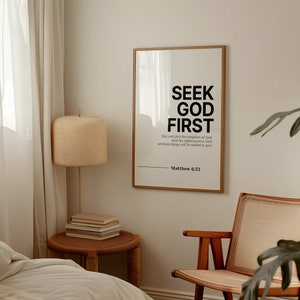 Puede incluir: Una impresi&oacute;n enmarcada con fondo blanco y texto negro que dice "Busca primero a Dios" y una cita de Mateo 6:33. La impresi&oacute;n est&aacute; colgada en una pared blanca en una habitaci&oacute;n con una silla de madera y una l&aacute;mpara.