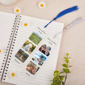 May include: Clear acrylic bookmark with a blue tassel and a silver tassel. The bookmark features six photo inserts with the words "Peace and love to you" and names "Benjamin" and "Amelia". The bookmark is on a spiral notebook.