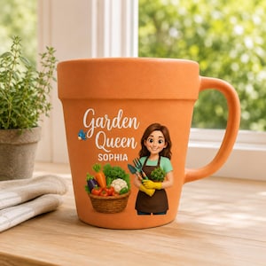 Puede incluir: Una taza de cerámica color terracota con forma de maceta. El frente presenta el texto Garden Queen y el nombre Sophia, junto a una ilustración de una persona con camisa verde y delantal marrón sosteniendo herramientas de jardín cerca de una cesta.
