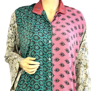 Könnte beinhalten: Ein Hemd mit Knopfleiste und einem einzigartigen Patchwork-Design. Das Hemd hat auf der einen Seite ein teal- und braunes Blumenmuster, auf der anderen einen rosa Paisley-Druck und gemusterte Ärmel. Der Kragen ist rot-rosa.