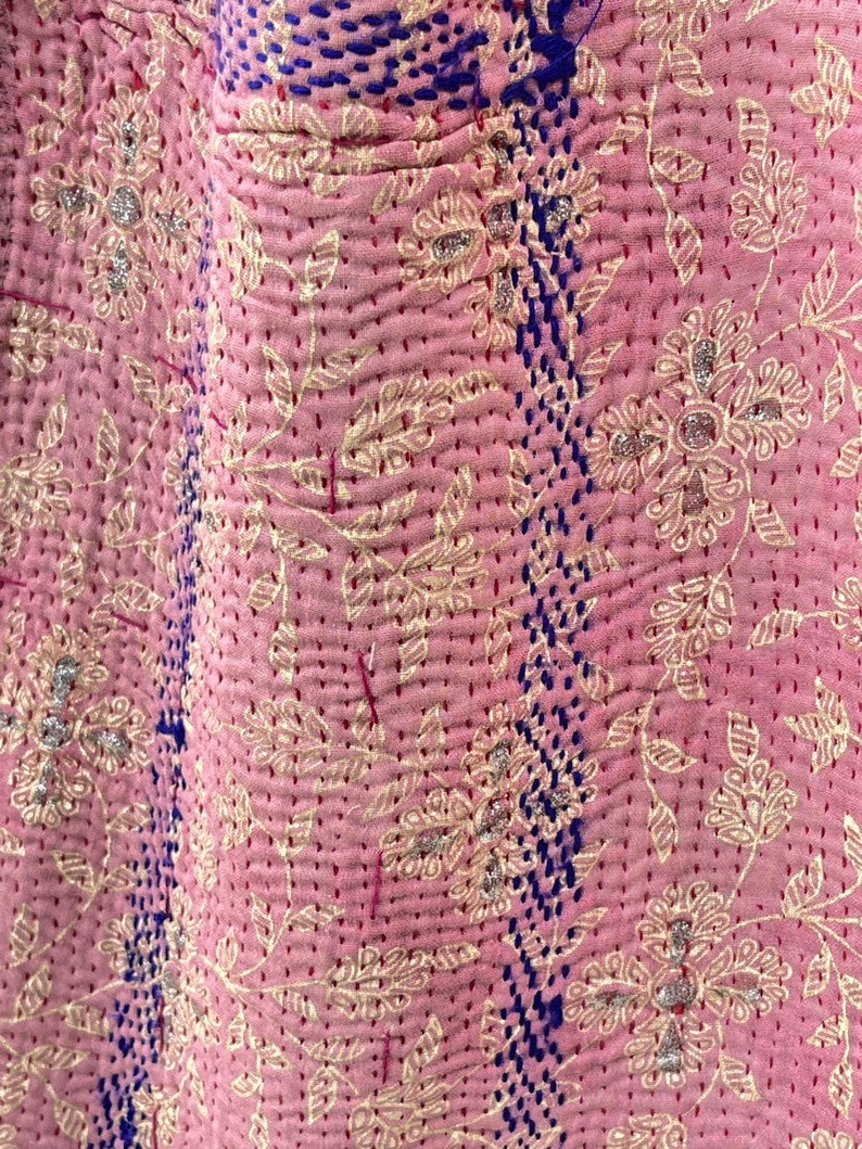 K&ouml;nnte beinhalten: Rosa Kantha-Steppdecke mit floralem Muster und blauen N&auml;hten. Die Decke ist aus Baumwolle und hat ein weiches, handgen&auml;htes Gef&uuml;hl.