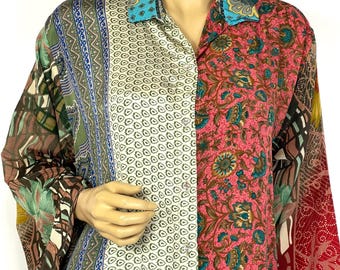 Puede incluir: Una camisa de manga larga con un diseño de patchwork. La camisa presenta una variedad de estampados, incluyendo florales, geométricos y abstractos en tonos de verde, azul, rosa y rojo. El cuello es de color turquesa contrastante.