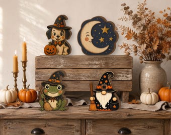May include: Four decorative wooden Halloween cutouts featuring a puppy in a witch hat with a pumpkin, a crescent moon with stars, a frog in a witch hat holding a broom, and a gnome in a witch hat holding a broom and a small black cauldron.