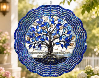May include: A blue and silver metal wind spinner with a tree of life design. The tree features blue and gold leaves, with the text "65th Wedding Anniversary" and names "David & Sophia" and the date "02.27.1961".