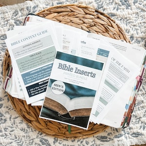Puede incluir: Una colección de insertos bíblicos impresos, incluido un paquete de "Men's Edition", y una Guía de Contenido Bíblico, colocados en una cesta tejida. Los insertos presentan texto sobre el contexto, el idioma y la literatura de la Biblia. La Biblia abierta es visible.