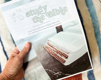 Peut inclure: Un livre intitulé "How to Study the Bible" avec du texte vert clair. Le livre est ouvert, révélant des pages et des onglets à bords marron. Le fond est une couverture à motifs avec des rayures bleues, blanches et orange.